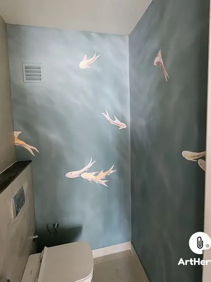 Even a washroom can be a canvas for beautiful art. We painted this serene underwater scene with delicate fish on a textured blue wall, turning a simple powder room in Gurgaon into a tranquil escape.