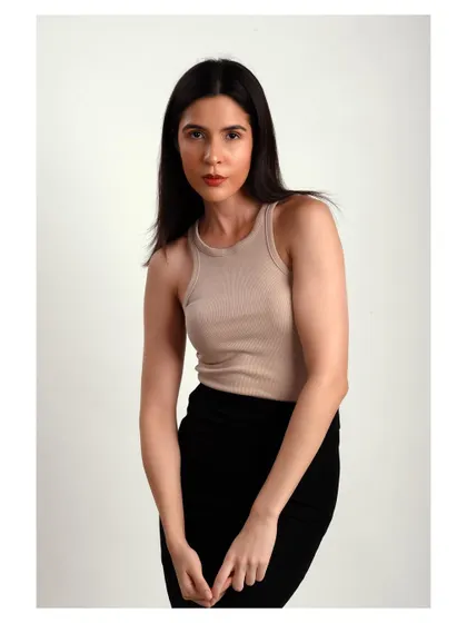 A simple and classic studio portrait. The neutral-colored top and clean background keep the focus on the model's natural beauty.