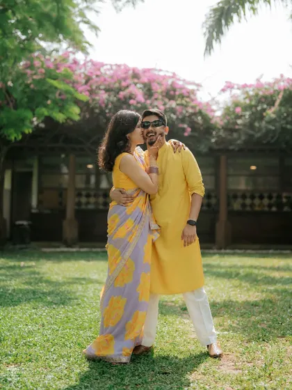 A playful moment where the bride dabs some Haldi on the groom's cheek. It’s a fun, candid shot that tells a story.