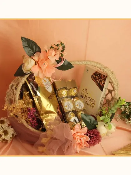 A beautiful basket hamper ideal for a wedding or anniversary. It's filled with premium chocolates like Ferrero Rocher and almond brittle, and decorated with delicate artificial flowers.