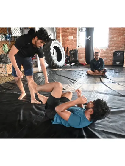 Students drilling guard passing techniques while the coach observes.