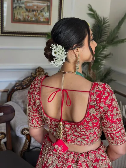 This soft, twisted bridal bun is adorned with a delicate arrangement of baby's breath, creating a look that is both romantic and sophisticated. It’s a versatile style that works beautifully for the ceremony or reception.