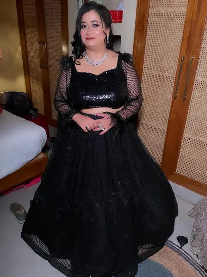 The full look, showing how the feathered sleeves and sequin details of her outfit are balanced by the elegant makeup and hair.