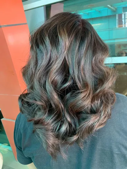 A beautiful example of subtle highlights on medium-length hair, styled into soft waves for a natural, beachy feel.