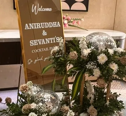 A personalized welcome sign for a cocktail party. We used a mirrored sign for a modern look and added disco balls and floral arrangements to hint at the fun, celebratory night ahead.