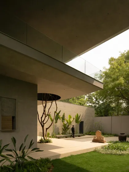 The integration of nature is a key theme, seen in the voids cut for trees and the placement of art and sculpture in the garden. The architecture frames and celebrates the natural environment.