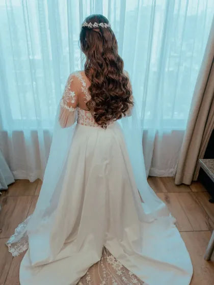 A back view of this stunning hairstyle. The long, soft waves and delicate accessory create a romantic and ethereal look.
