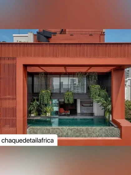 A view of the rooftop pool and lounge at Sarvasva, showcasing the integration of hanging plants within the double-height space, creating a lush canopy above the water.