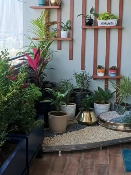 A thoughtfully designed zen garden corner on a balcony, creating a pocket of tranquility. This setup features a mix of pebbles, a custom water element, and carefully selected plants on a raised platform, demonstrating how even small spaces can be transformed.