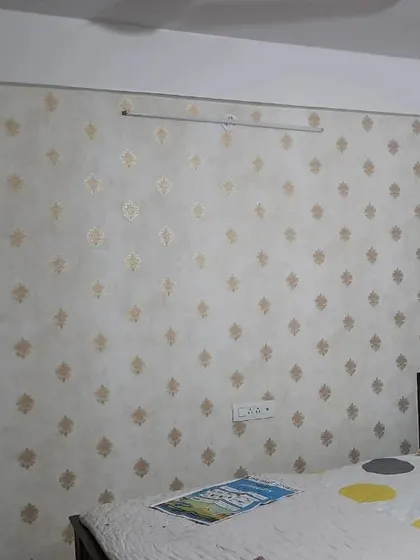 A simple and elegant wallpaper with a small, repeating gold motif on a light background. This is a great choice for adding a subtle touch of class to a bedroom without being too busy.