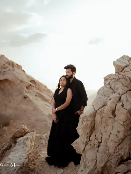 Using the unique rock formations of the Dubai desert to frame the couple. This shot highlights the rugged beauty of the landscape and the couple's serene connection within it.