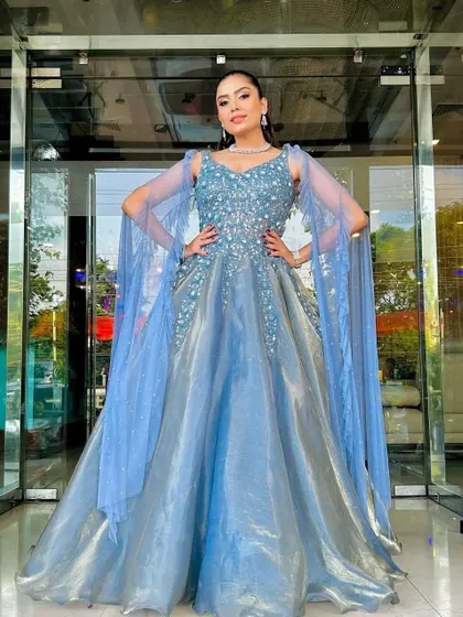 A full front view of the shimmering blue-grey gown with its elegant cape sleeves, a perfect rental for a reception or formal party.
