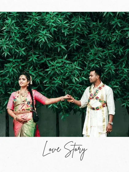 A classic portrait of the couple set against a wall of lush greenery, creating a beautiful and natural frame for their love story.