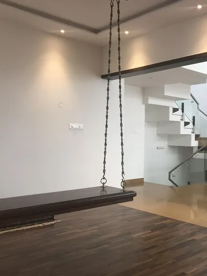 A traditional wooden swing, or 'unjal', incorporated into a modern living space, adding a touch of heritage and playful nostalgia.