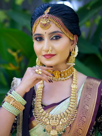 A classic portrait pose. The makeup is bold yet elegant, with defined eyes and lips that stand out against the traditional attire.