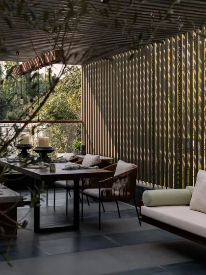 The upper terrace at Pràna, a perfect spill-out space for hosting parties. The slatted wooden screen provides privacy while allowing light and air to filter through.