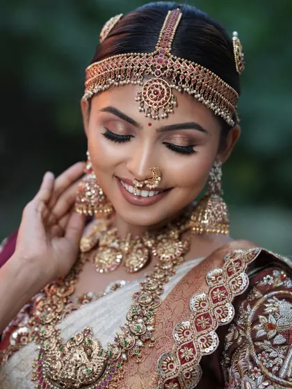 A happy, smiling close-up of the bride. The soft brown and gold eye makeup and the perfectly matched lip color enhance her joyful expression.