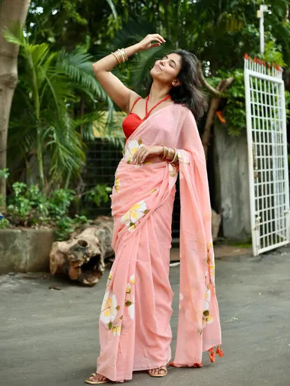 Modeling a hand-painted floral saree, this full-length shot captures a carefree and joyful moment, perfect for summer collections and lifestyle brands.