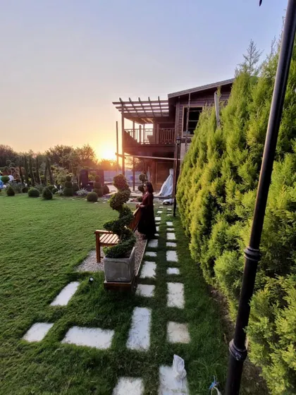 Our landscape design was executed at this farmhouse while the house was still under construction. A stepping stone path winds past spiral topiaries and a wall of golden cypress trees.