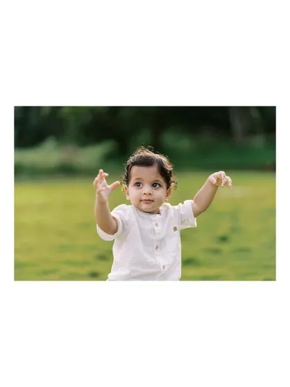 A baby boy reaching out, full of curiosity. We were lucky to get this shot after a rain delay.