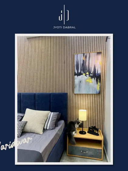 A modern bedroom in our Haridwar project with a focus on texture. The fluted wall panel behind the bed adds depth and character, complemented by the abstract artwork.