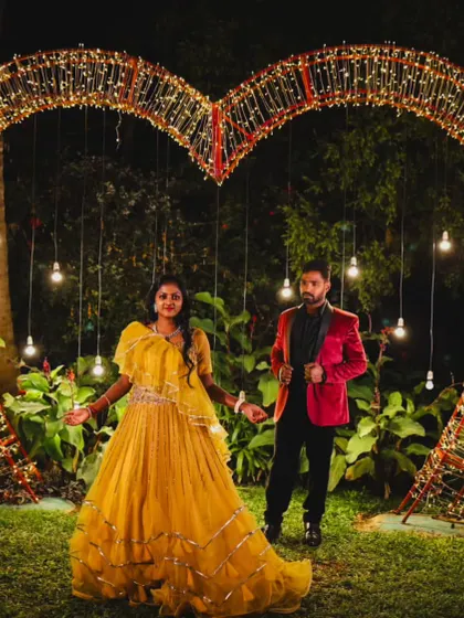 A magical night-time shot with a heart-shaped light installation, perfectly complementing the couple's romantic outfits.