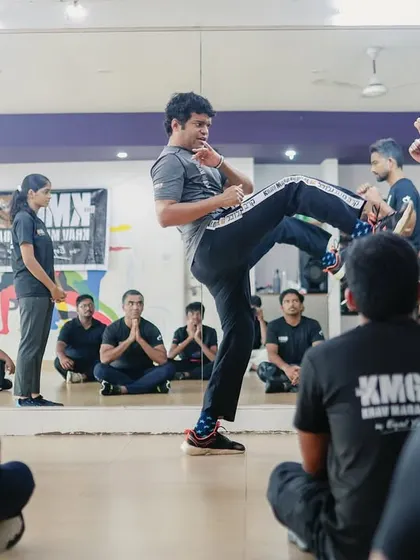 A student demonstrates a defensive kick during our Third Party Protection Seminar in Mangalore, while others observe. This training teaches how to protect a friend or family member from an attack.