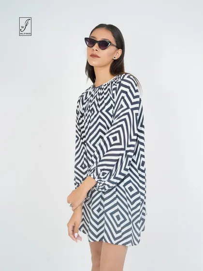 A black and white geometric print dress, shot to emphasize its bold pattern and simple silhouette.