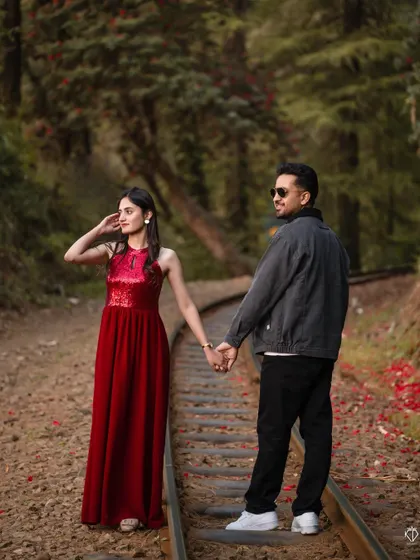 Walking hand-in-hand along the tracks, this shot captures a sense of journey and partnership against the backdrop of the forest.