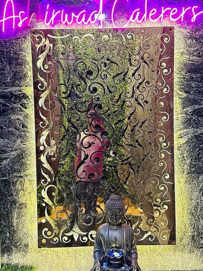 The decor at my banquet hall is designed to be both elegant and serene. This corner features intricate paneling, a calming Buddha statue, and our signature neon sign.