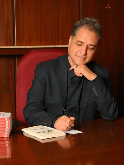 A shot of the author signing a copy of his book. This is a classic image for any author, perfect for promotional events and personal branding.