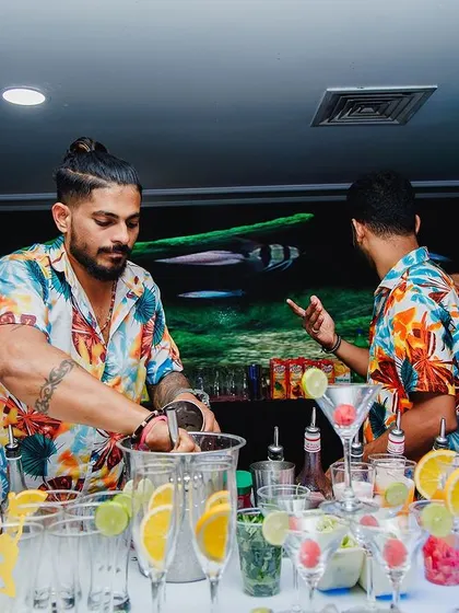 A bartender in his element, muddling fresh ingredients for a cocktail. This action shot captures the hands-on craft and attention to detail that goes into every drink we make.