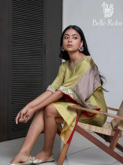 A relaxed and natural makeup look for Belle Robe. The makeup is fresh and minimal, complementing the earthy tones of the green and brown kaftan-style dress.