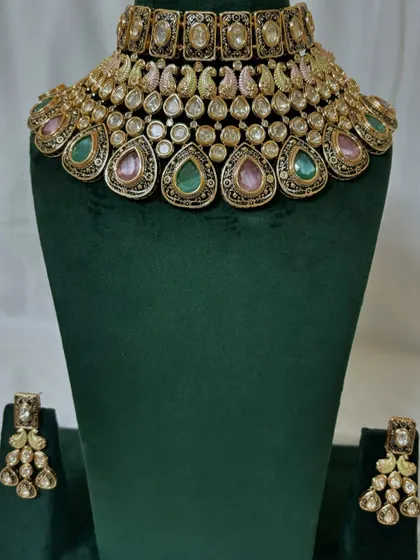 A multi-coloured choker necklace with pink and green stones. This rental piece can be paired with a variety of traditional outfits.