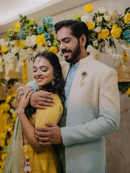 A beautiful couple portrait. Her Haldi makeup is soft and radiant, complementing her yellow and blue lehenga.