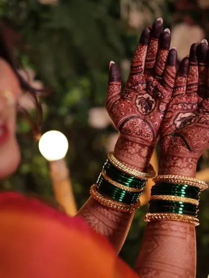 A happy bride showing off her dark mehndi stain. The color is deep and even, which is exactly what you want for your wedding photos.
