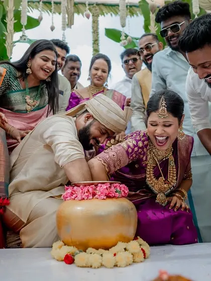 The fun and games of wedding rituals. This moment of laughter during a post-wedding game shows the playful spirit and strong bond between the couple and their families.