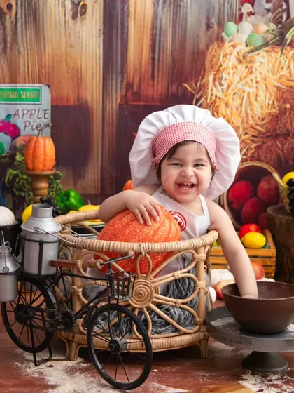 Having fun at the market. The bicycle prop adds another layer of playfulness to this already charming little chef theme.
