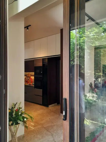 This elegant kitchen overlooks a canopy of greenery, blurring the line between indoors and out. We used a subtle palette of white and grey solid colors, which marry beautifully with the luxurious wood and marble flooring for a sophisticated look.