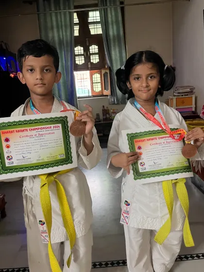 The winning feeling doesn't end at the competition. Two of our students proudly displaying their medals and certificates of appreciation at home.
