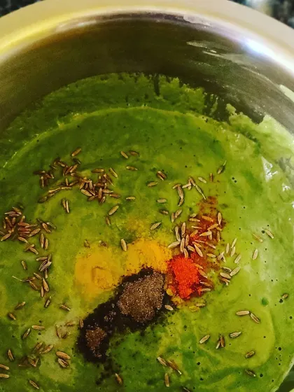 Preparing the batter for our Besan Palak Chilla, with a vibrant green spinach base and a mix of aromatic Indian spices.