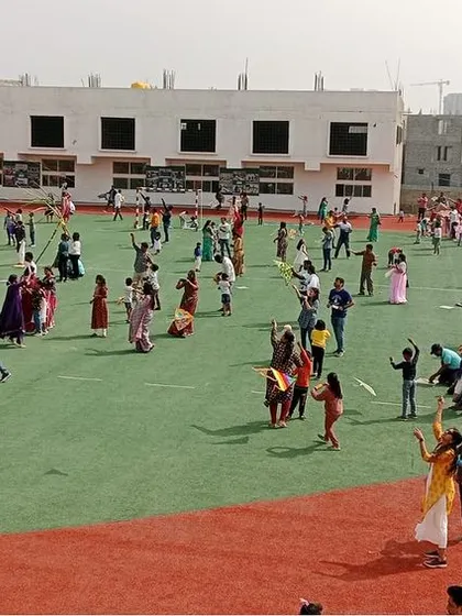 The school ground is a canvas of color and activity as families enjoy the kite-flying festival together.
