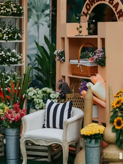Inspired by London's Borough Market, this "Flower Bar" was a central feature of a farmers' market themed event. The setup includes fresh flowers in galvanized buckets, a classic armchair, and woven baskets to evoke a feeling of rustic elegance.