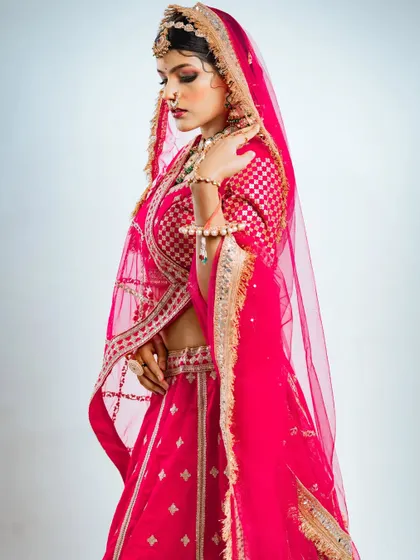 A graceful side profile that captures the intricate details of the blouse and the traditional bridal jewellery.