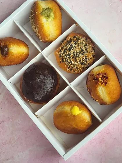 A top-down view of our assorted bombolini box, showing the variety of fillings and toppings I offer. From Nutella to pistachio, there's a flavor for everyone.