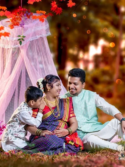 A beautiful family dressed in traditional attire for an outdoor maternity shoot. The older son whispers to the baby in his mother's belly, creating a touching and memorable family portrait.