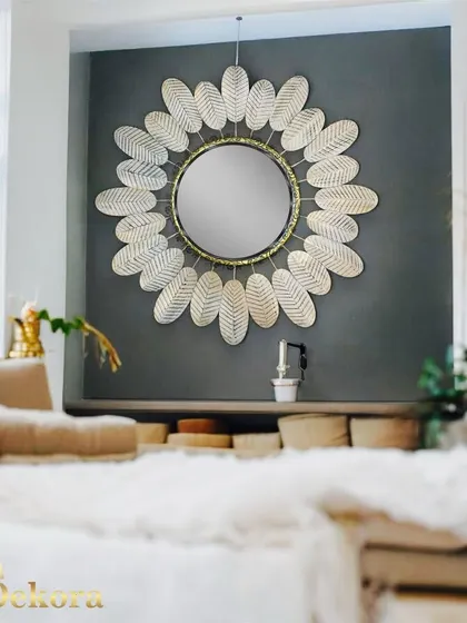 Another view of the white leaf mirror, this time in a cozy, light-filled bedroom setting.