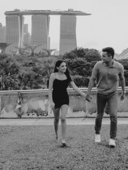 A classic black and white walking portrait with Marina Bay Sands in the background. This timeless style highlights the couple's interaction and the iconic location.