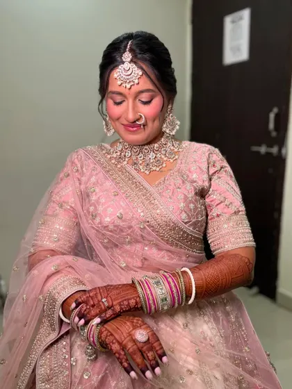 Another candid shot of the final touch-ups, capturing the details of her intricate jewelry and soft makeup.