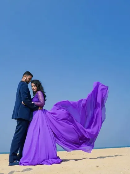 This shot captures the romantic essence of a pre-wedding beach shoot, with the lavender gown's tail creating a beautiful, flowing line.